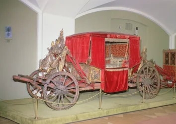 Carruaje inglés, madera tallada, decoración pintada y dorada con cortinas de terciopelo